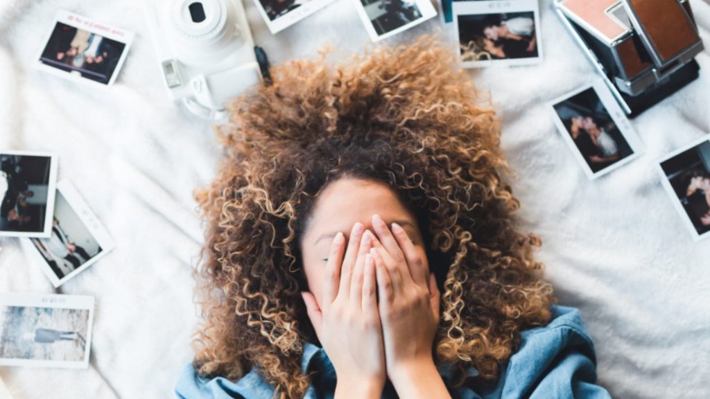 frau auf bett mit polaroids